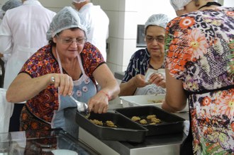 Duas mulheres colocando bolachas em formas