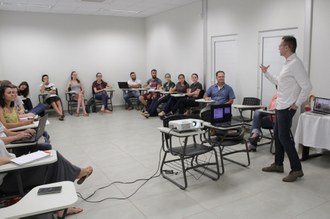 Homem realizando palestra com alunos