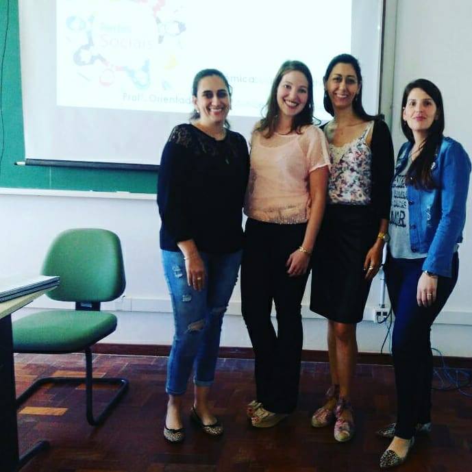 Quatro mulheres olhando para a câmera em uma sala de aula.