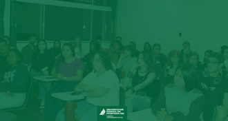 Na imagem uma foto de estudantes em sala de aula. Sobre a foto um filtro na cor verde.