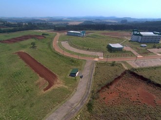 Foto registrada do alto mostra parte da infraestrutura do Campus Laranjeiras do Sul. Ao lado esquerdo da imagem observa-se a pista de aeromodelismo.