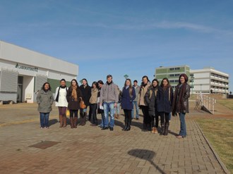 Varias pessoas em pé posam para foto ao lado dos laboratórios do Campus Laranjeiras do Sul.