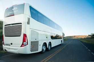 foto de um ônibus branco numa estrada