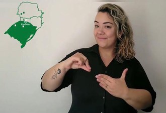 Mulher do lado direito fazendo interpretação de libras. Do lado esquerdo no alto aparece um mapa da região sul do país